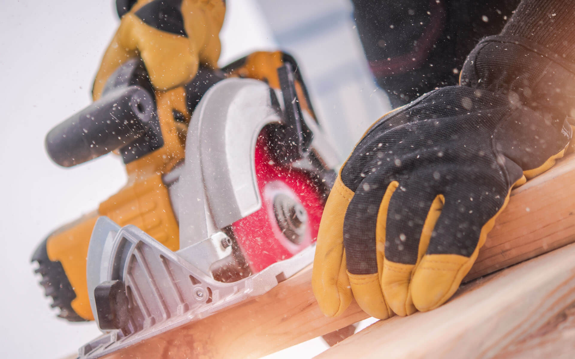 Photo of a person using a circular saw to cut a piece of wood